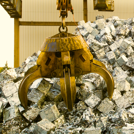 Industrial claw lifting crushed aluminum scraps for recycling